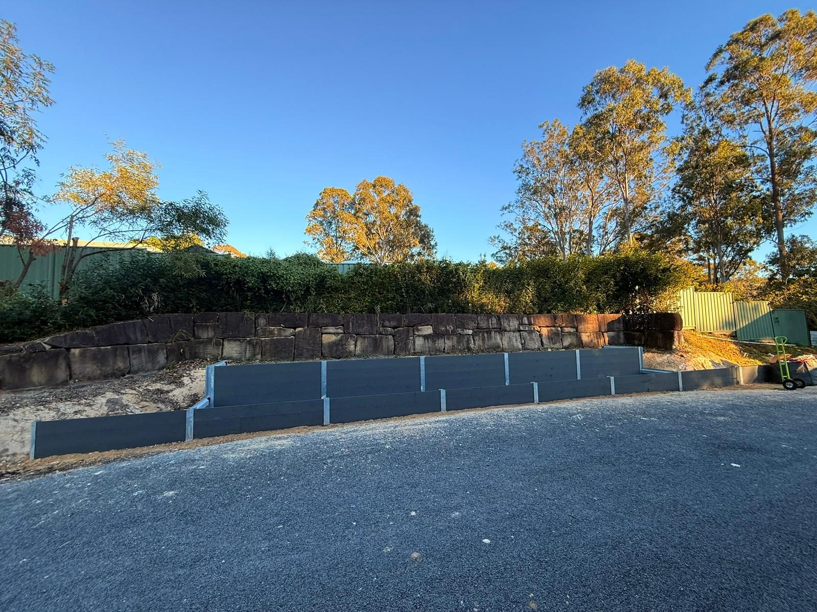 Retaining wall excavation and posts in progress